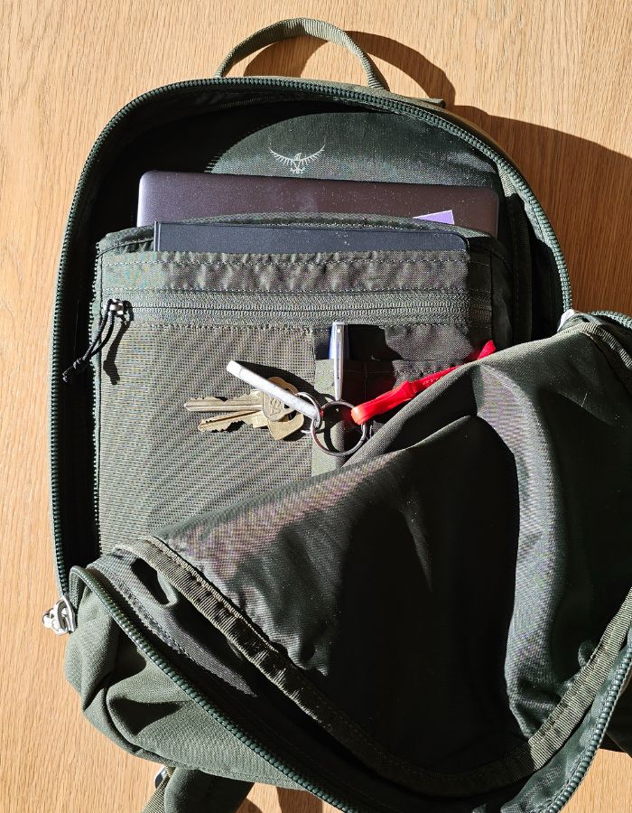 Öppen Osprey Arcane Small laptop ryggsäck med innehåll synligt.