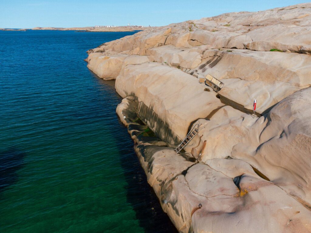 Marmorbassängens rosa granitklippor sluttar ner och slutar abrupt i det turkosa havet.