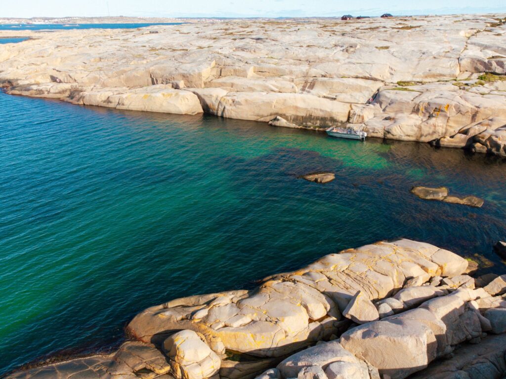 Viken som bildar marmorbassängen. Turkost vatten och rosaskimmrande granitklippor.