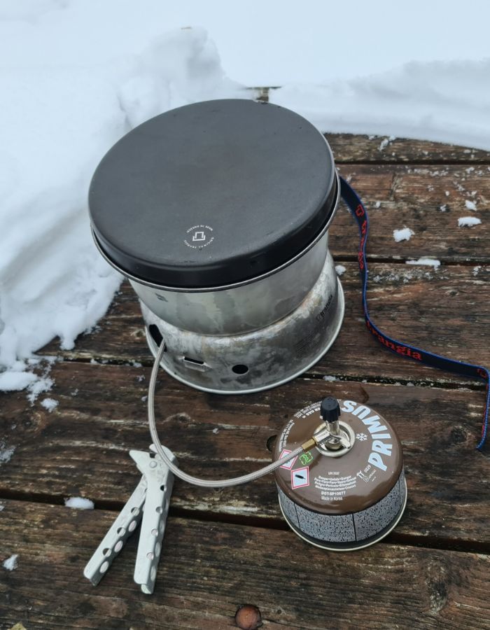 Trangias stormkök är bäst i test. Det står uppställt på ett snöigt träbord och är kopplat till primus vintergas.